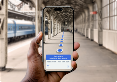A person holding a smartphone in a train station, displaying an augmented reality navigation interface with blue circular markers leading to Platform 9 – Central